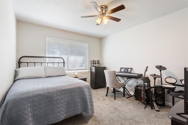 bedroom featuring ceiling fan, carpet floors, and a textured ceiling