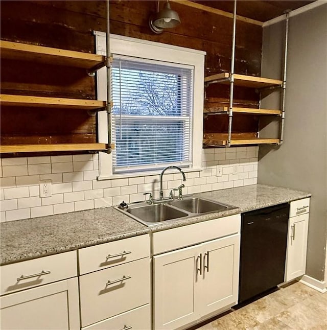 kitchen featuring sink, black dishwasher, white cabinets, light stone countertops, and backsplash