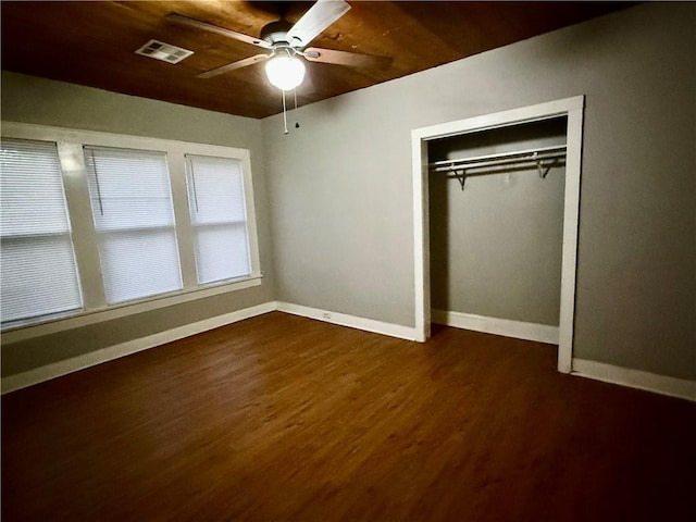 unfurnished bedroom featuring dark wood-type flooring, ceiling fan, and a closet