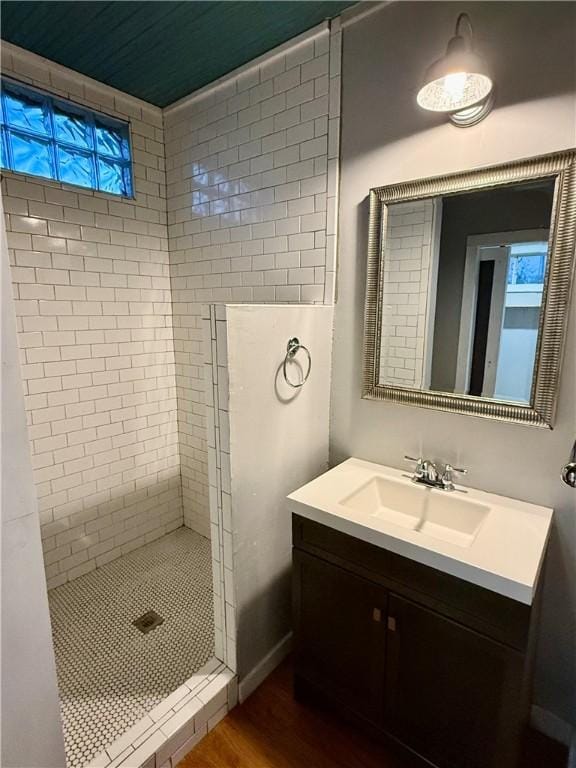 bathroom featuring vanity, hardwood / wood-style flooring, and tiled shower