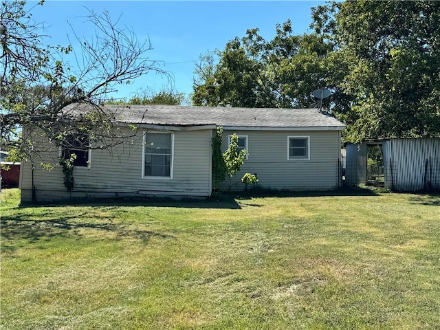 rear view of house featuring a yard