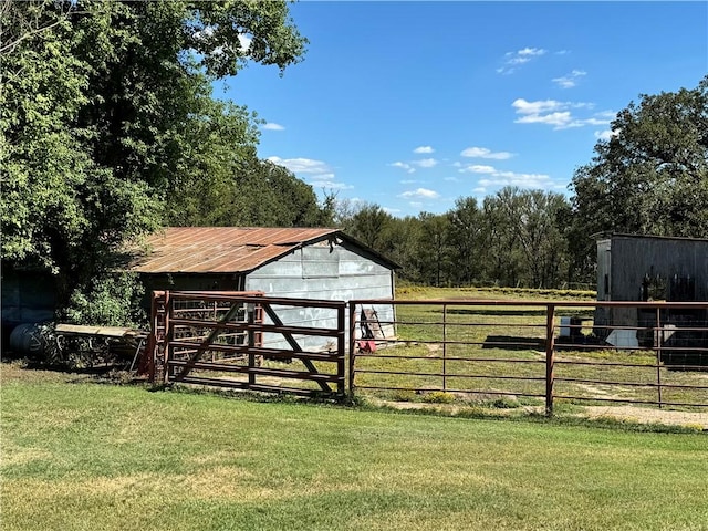 view of outbuilding featuring a lawn and a rural view