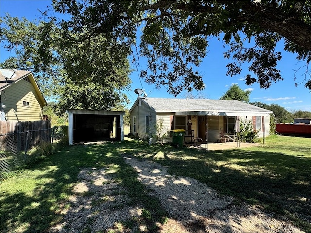 back of property featuring a lawn and an outbuilding