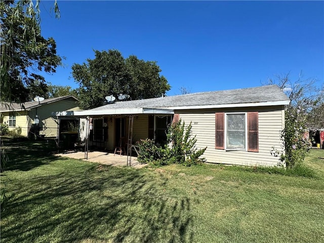 back of property with a patio area and a yard