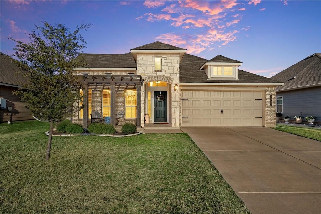 view of front of home with a garage and a lawn