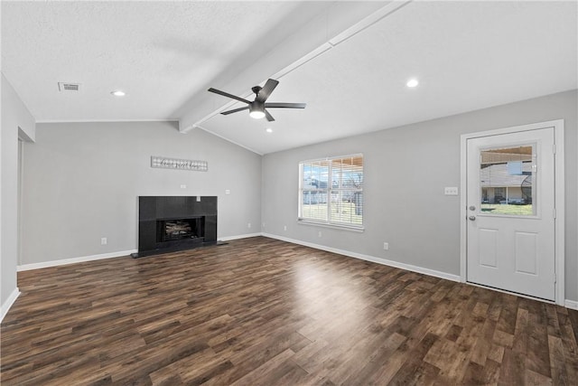 unfurnished living room with vaulted ceiling with beams, ceiling fan, dark wood-type flooring, and a textured ceiling