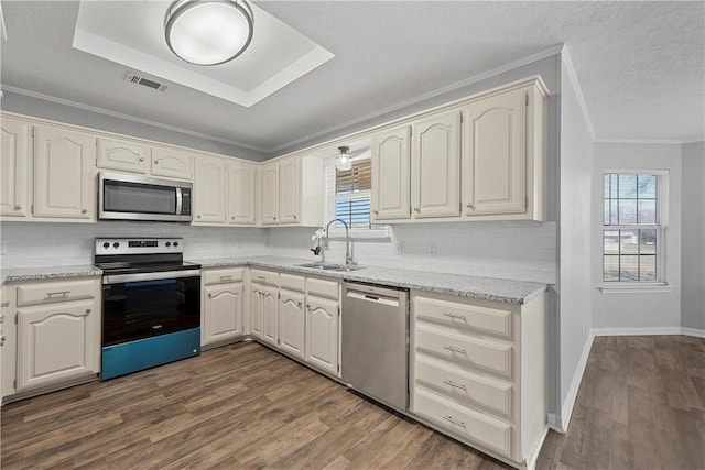 kitchen featuring light stone countertops, sink, dark wood-type flooring, stainless steel appliances, and backsplash