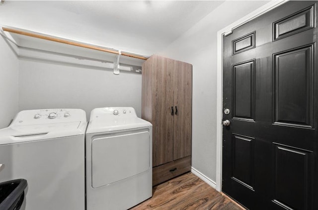 washroom with dark hardwood / wood-style flooring and washing machine and dryer