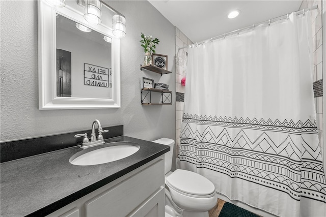 bathroom featuring vanity, toilet, and walk in shower