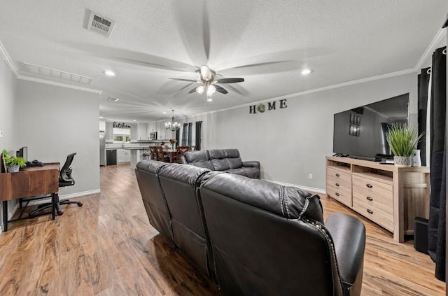 living room featuring ornamental molding, light wood-type flooring, and a textured ceiling