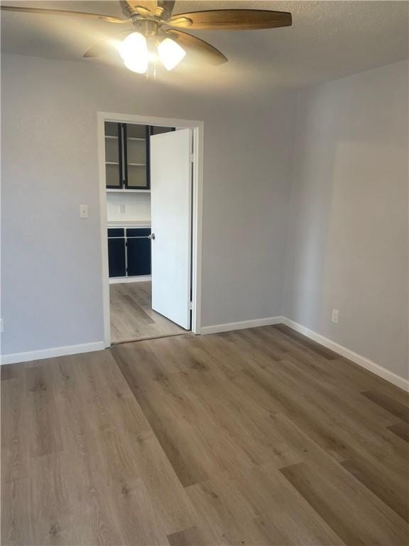 empty room featuring ceiling fan and hardwood / wood-style floors