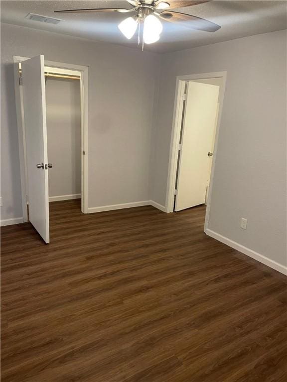 unfurnished bedroom featuring a closet, ceiling fan, and dark hardwood / wood-style flooring