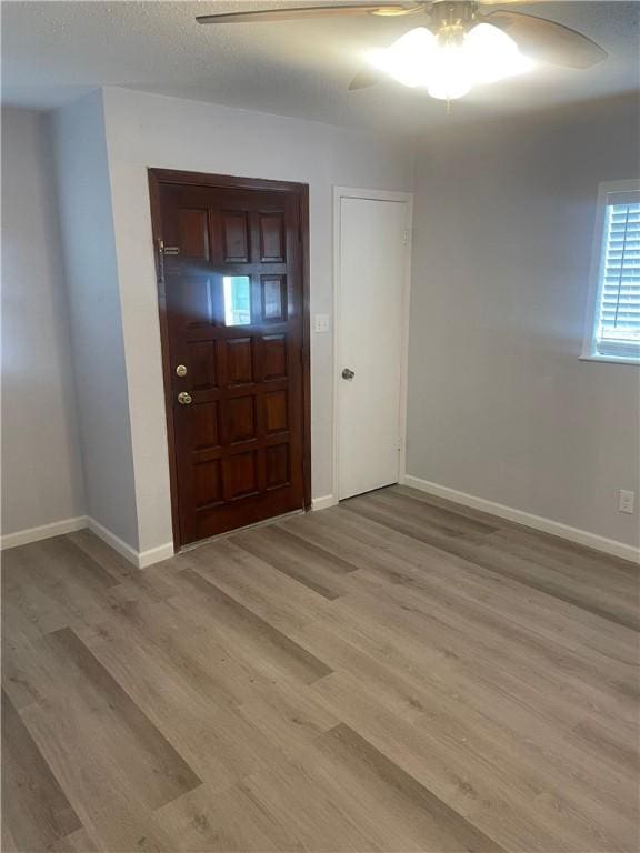 foyer entrance with ceiling fan and light hardwood / wood-style floors