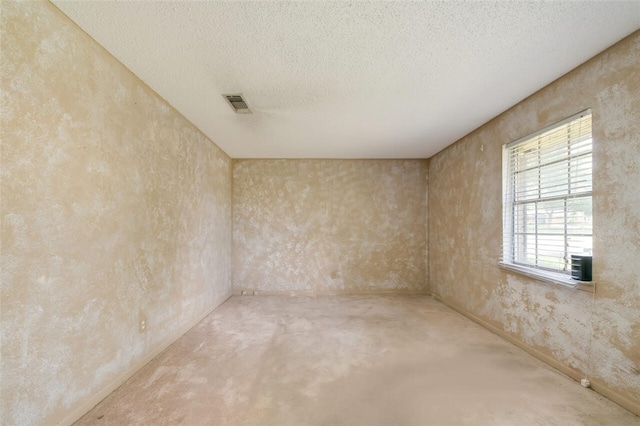 unfurnished room with a textured ceiling