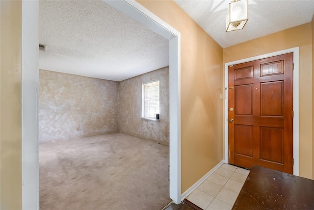 foyer with light colored carpet and a textured ceiling