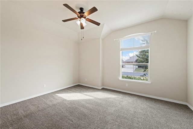 carpeted empty room featuring vaulted ceiling and ceiling fan