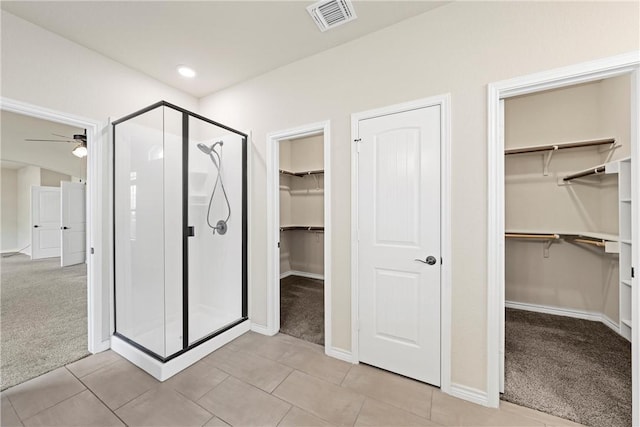 bathroom featuring tile patterned floors, ceiling fan, and a shower with shower door