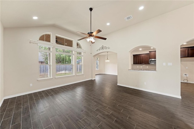 unfurnished living room with ceiling fan, dark hardwood / wood-style flooring, and high vaulted ceiling