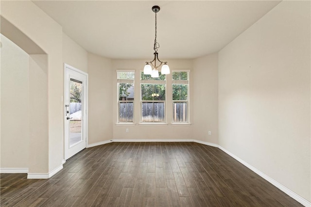 unfurnished dining area with dark hardwood / wood-style floors and a notable chandelier