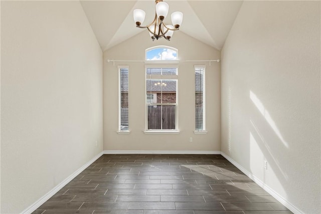 spare room featuring dark wood-type flooring, lofted ceiling, and a notable chandelier