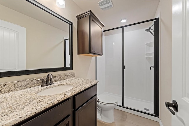 bathroom with tile patterned floors, vanity, a shower with shower door, and toilet