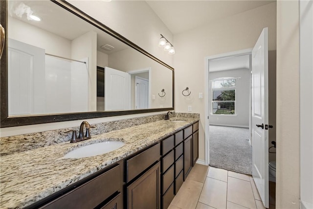 bathroom featuring tile patterned flooring, vanity, toilet, and walk in shower