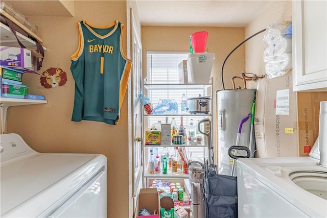 clothes washing area with cabinet space, independent washer and dryer, and water heater