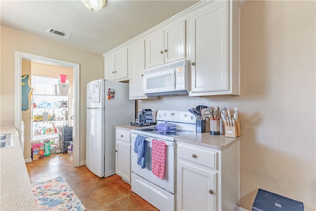 kitchen featuring light tile patterned floors, light countertops, visible vents, white cabinetry, and white appliances