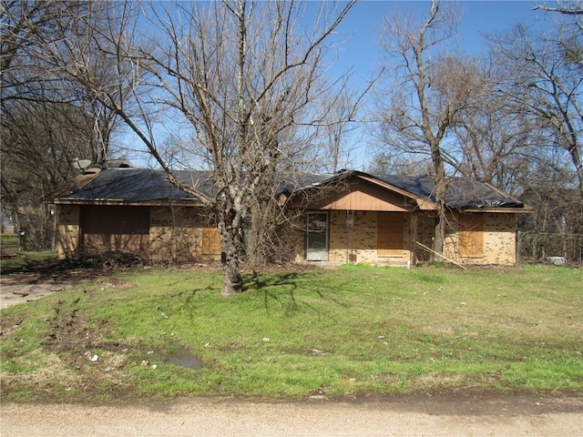 view of front of property featuring brick siding and a front lawn