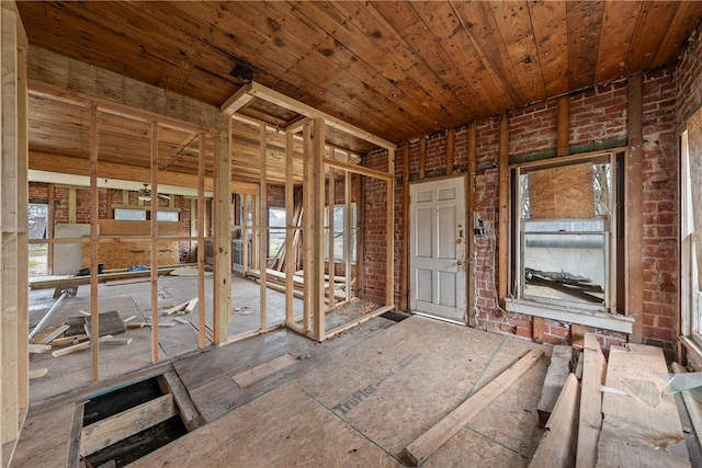 misc room with wood ceiling and brick wall