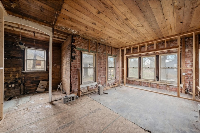 misc room with wooden ceiling and brick wall