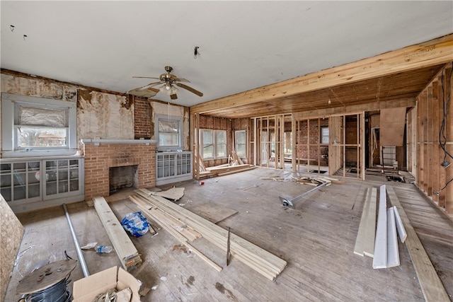 misc room with a fireplace and ceiling fan