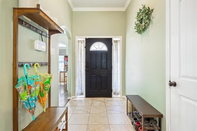 foyer with crown molding, light tile patterned flooring, baseboards, and arched walkways