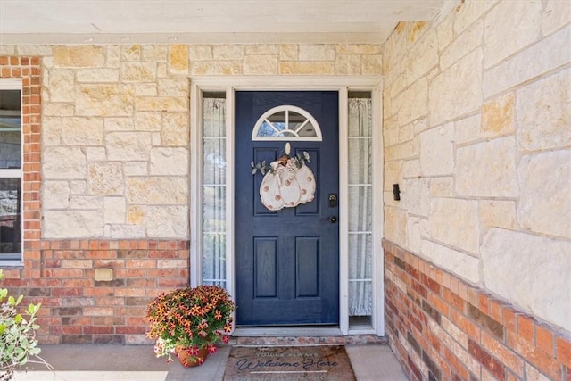 doorway to property with brick siding and stone siding