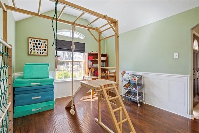 interior space with vaulted ceiling, wood finished floors, and wainscoting