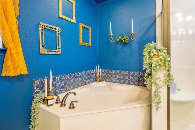 bathroom with a garden tub and a textured wall