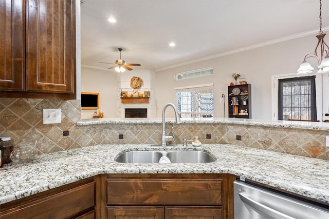 kitchen featuring ornamental molding, dishwasher, light stone countertops, and a sink