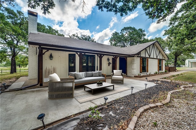 rear view of house with an outdoor living space and a patio