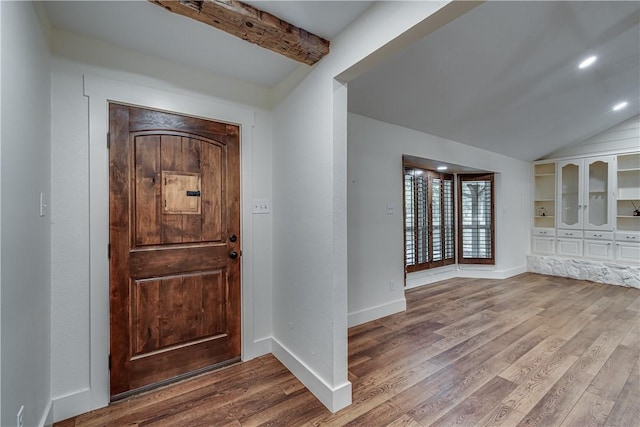 entrance foyer with vaulted ceiling with beams and wood-type flooring