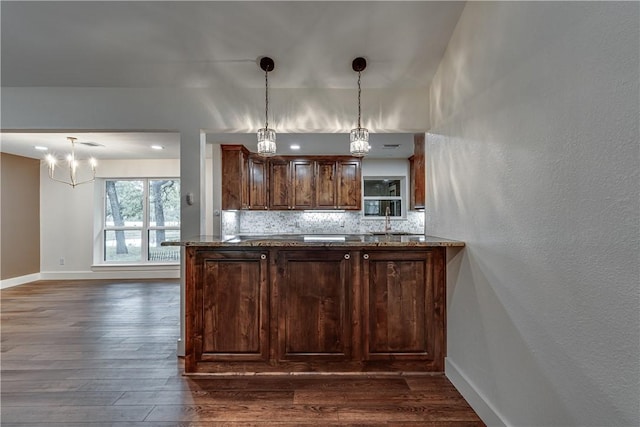 kitchen with tasteful backsplash, sink, hanging light fixtures, and dark hardwood / wood-style floors