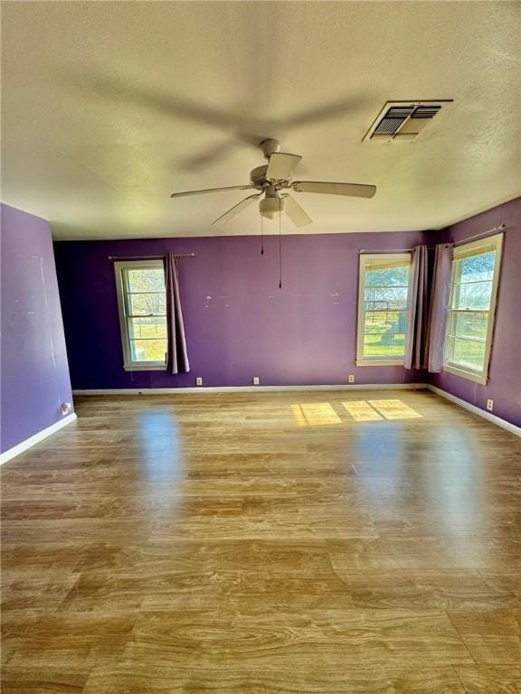 empty room with ceiling fan and light hardwood / wood-style floors