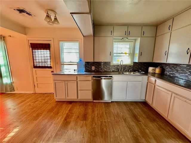 kitchen featuring tasteful backsplash, sink, stainless steel dishwasher, and light wood-type flooring