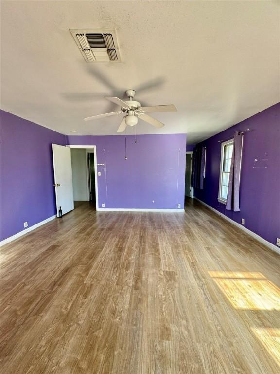 spare room with light wood-type flooring and ceiling fan