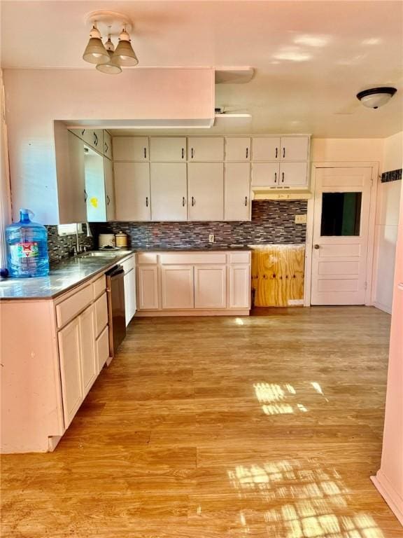 kitchen with sink, light wood-type flooring, black dishwasher, tasteful backsplash, and white cabinetry