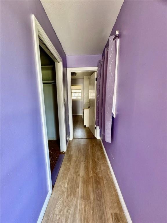 corridor with hardwood / wood-style floors