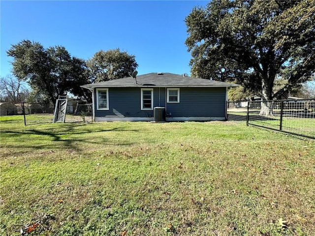 back of house featuring a lawn and central air condition unit