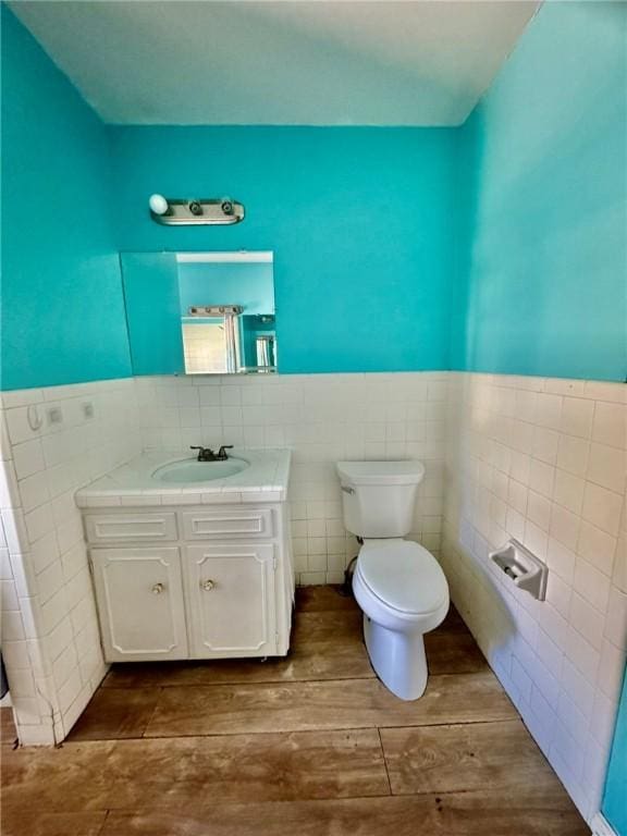 bathroom with vanity, tile walls, and toilet