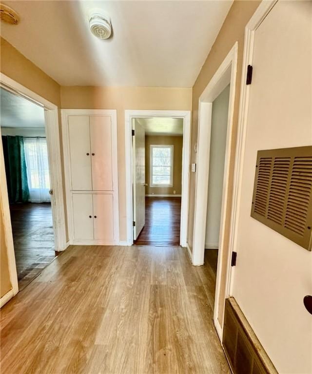 hallway with light hardwood / wood-style floors