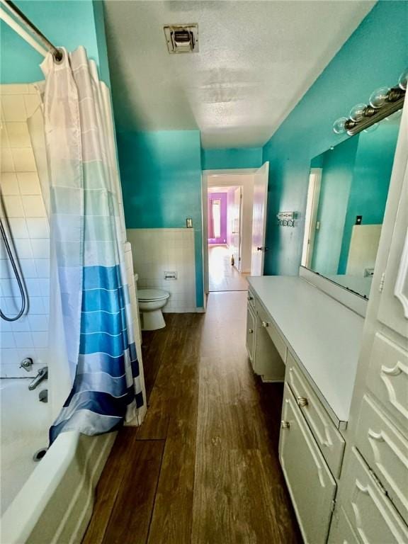 full bathroom with vanity, toilet, wood-type flooring, and shower / tub combo with curtain