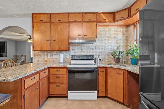 kitchen with kitchen peninsula, decorative backsplash, ceiling fan, sink, and white range with electric cooktop